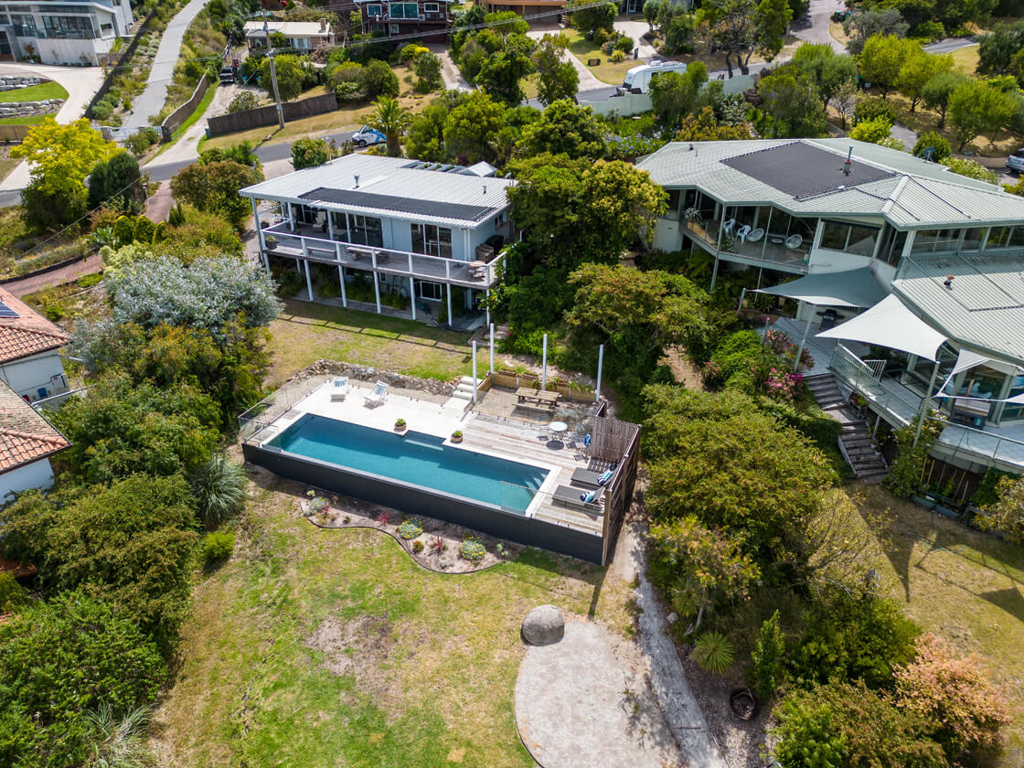 Aerial view of rectangular pool with panoramic views from a hilltop property