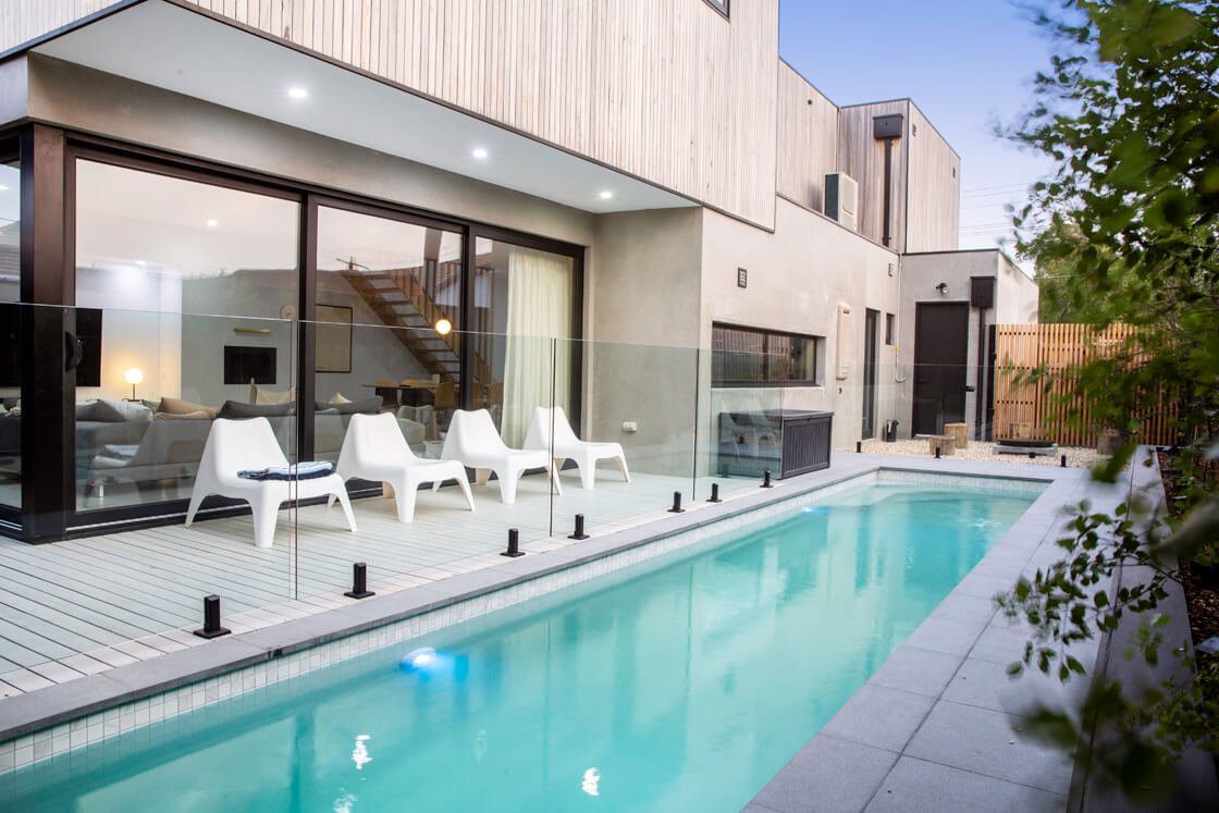 Lap pool beside Scandinavian-style house with timber cladding and minimalist design
