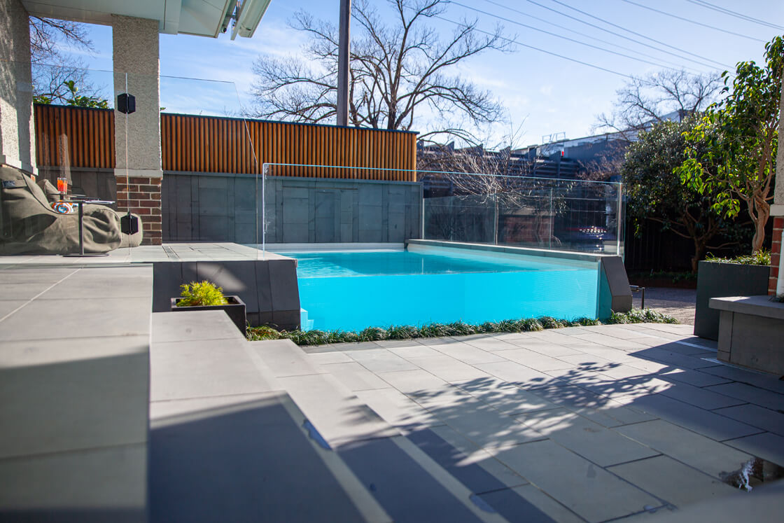 Modern courtyard pool with clean lines and architectural paving