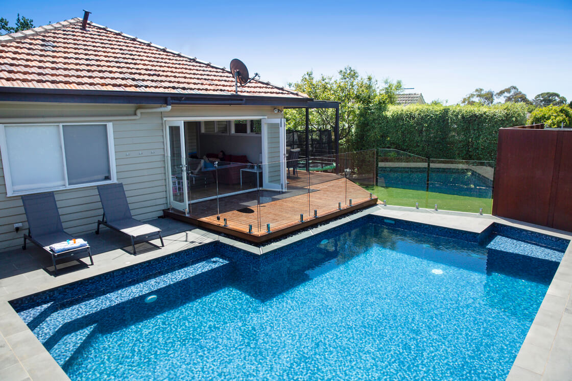 Rectangular family pool with sun lounges and adjacent deck